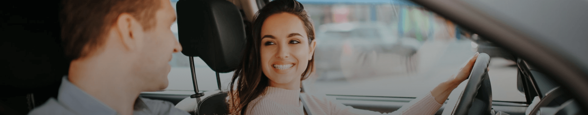 Deux personnes souriantes dans une voiture